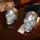 A pair of contemporary chrome skulls