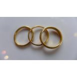 Two yellow gold band wedding rings marked 22ct gold and one other (probably 22ct gold), approx 7.