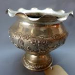 An Indian white metal planter, having scalloped rim, repousse decorated with vignettes of wild