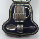 A Victorian silver christening set, comprising a cup, a spoon and a napkin ring, London 1881-1886,