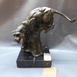 A cast bronze study of a panther on a naturalistic base, raised on a square marble base, signed