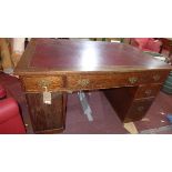 An Edwardian oak pedestal desk, with six drawers, one cupboard door, raised on plinth bases, H.78