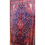 A fine North West Persian Hamadan rug, diamond medallion with repeating petal motifs on a sapphire