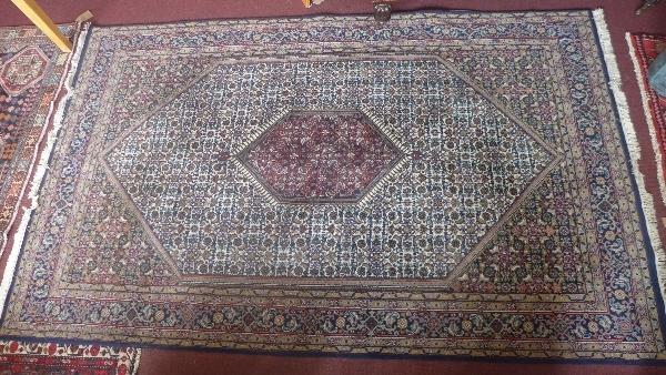 A Persian Bidjar carpet, with double floral diamond medallion, on a blue ground, surrounded by