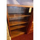 A mid 20th century oak bookcase, with two glass sliding doors, enclosing adjustable shelves, bears