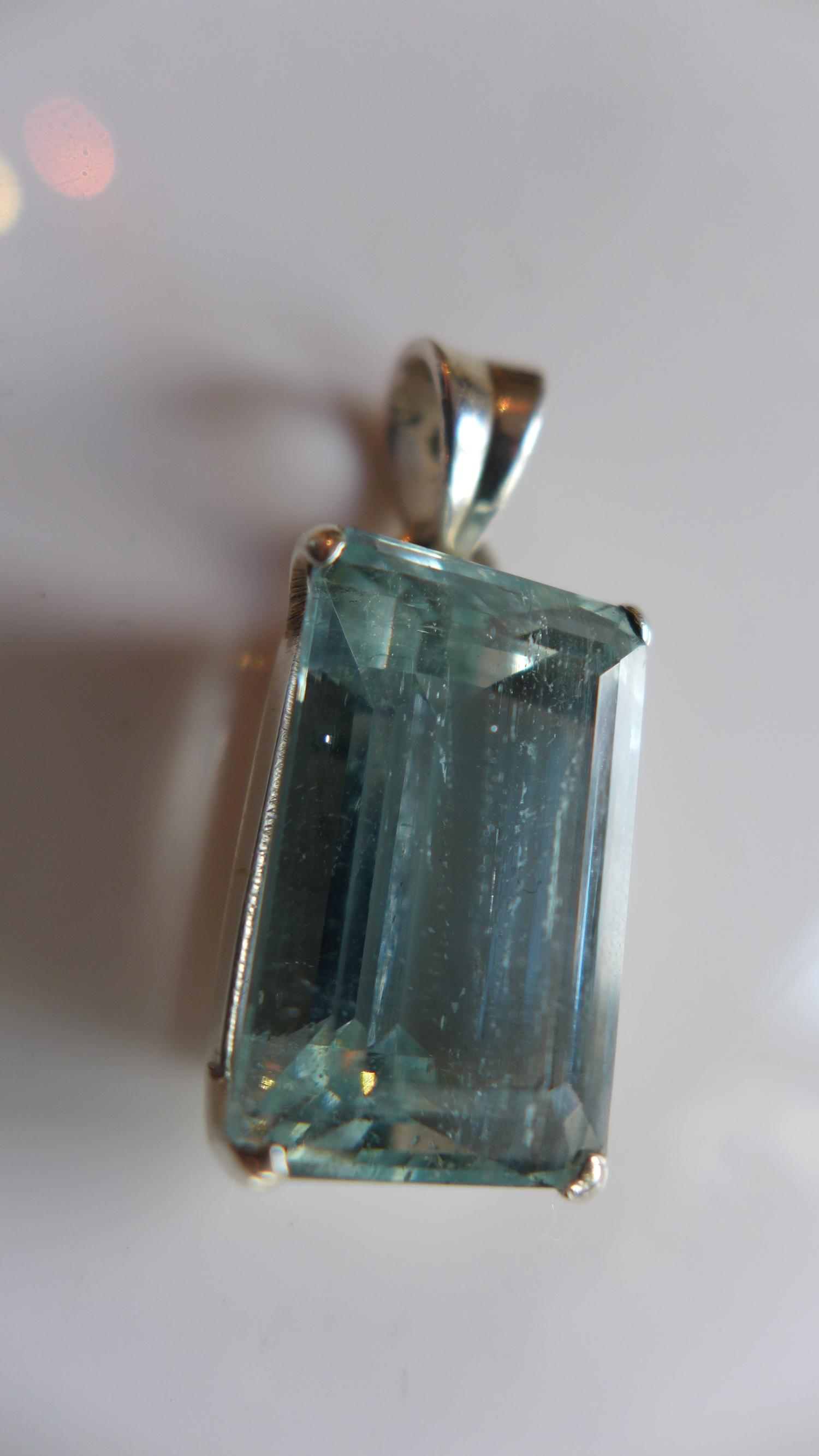 A ladies silver pendant, inset with baguette cut aquamarine, stamped 925 to clasp