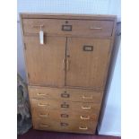 An early to mid 20th century teak laboratory chest, with five drawers, two cupboard doors, raised on