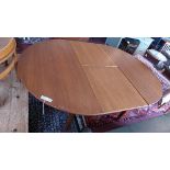 A mid 20th century Danish teak dining table, with fold in butterfly leaf, raised on tapered legs