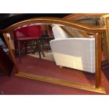 A contemporary gilt overmantel mirror, with arched pedestal top, floral decorated supports, bevelled