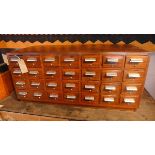 An early 20th century oak filing chest, with 28 drawers, raised on plinth base, H.52 W.112 D.49cm