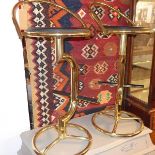 A pair of brass swivel bar stools