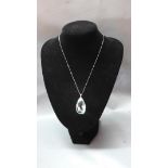 A large pear cut aquamarine pendant, with white metal mount set with diamonds