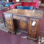 A Queen Anne style burr walnut kneehole desk, with nine drawers and one central cupboard door,