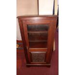 An Art Nouveau mahogany side cabinet, with part glazed and part carved door, raised on bracket feet,
