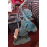 A cast iron fairy in the verdigris finish leaning on a branch, raised on naturalistic bases, H.60cm