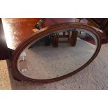 A 20th century oval oak mirror, with bevelled glass plate, 66 x 97cm