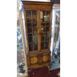 An early 20th century Maple and Co. burr walnut bookcase, with two glazed doors over two cupboard