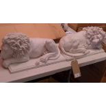 A near pair of faux marble recumbent lions, on stepped rectangular bases, the bases bearing
