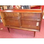 A mid 20th century Danish rosewood bookcase, with two sliding glass doors, raised on tapered legs,