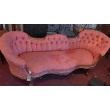 A Victorian walnut sofa, with button back damask upholstery, C-scroll decorated frame, raised on