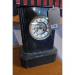 A late 19th century black slate mantel clock, drum movement, striking a bell, the white enamel Roman