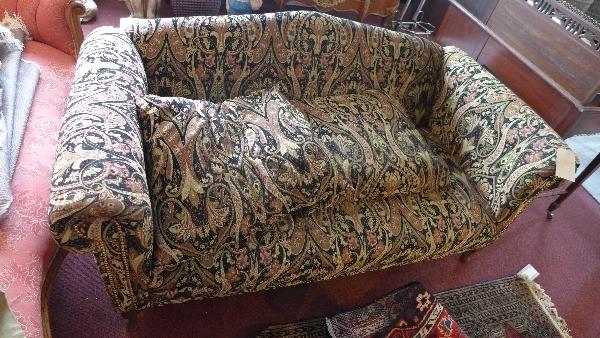 A 20th century camel back sofa, with paisley upholstery, raised on cabriole legs