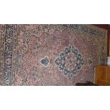 A Kashan carpet, with central floral medallion, on a salmon pink ground, surrounded by floral