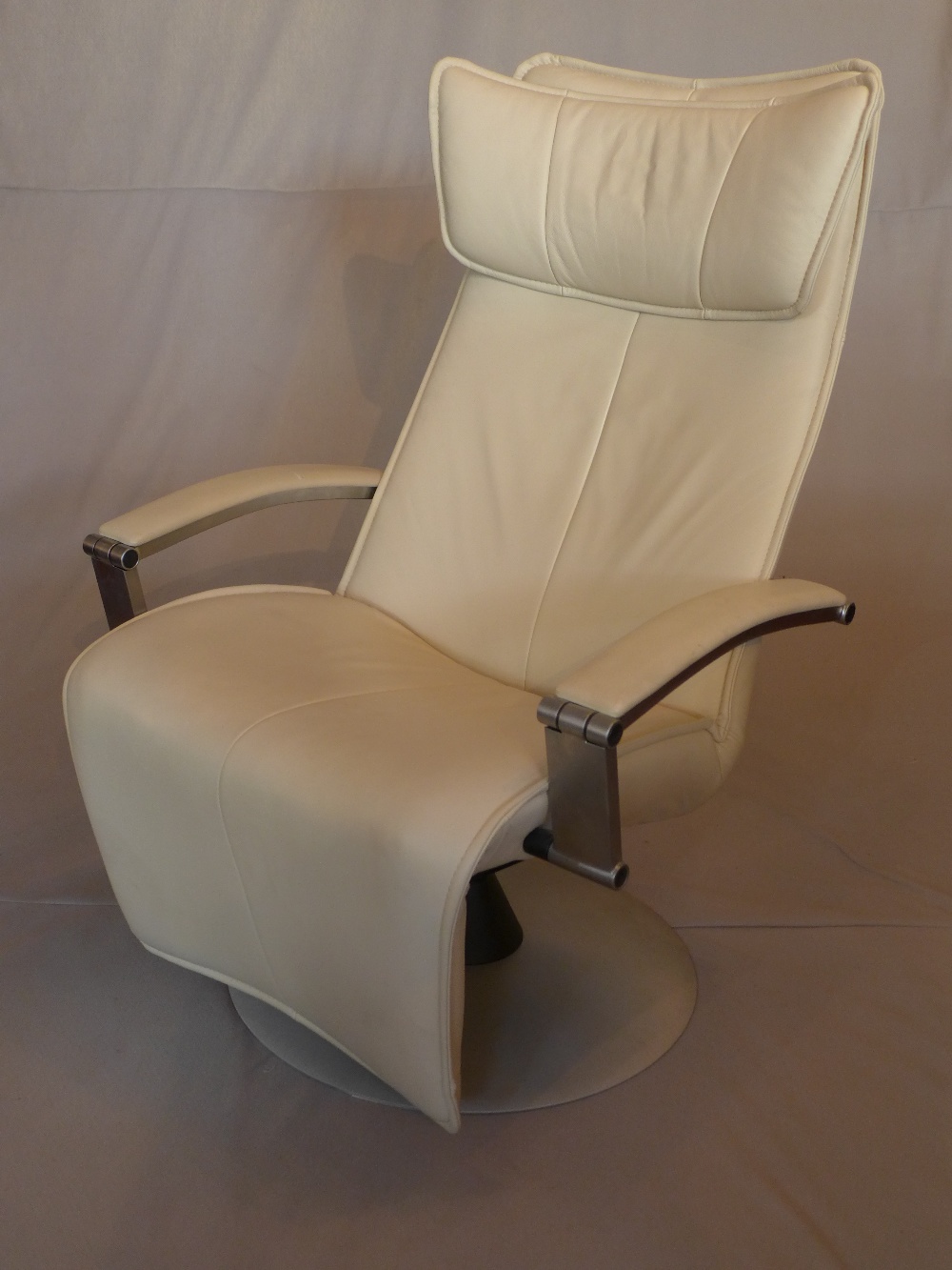 A contemporary Gravity cream leather reclining armchair, on circular base, H.115cm