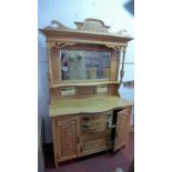 An Arts & Crafts oak bevelled mirrored back sideboard, with two central drawers, flanked by two