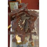 A 20th century German cuckoo clock, brass movement, Roman dial, with carved leaf decoration and bird