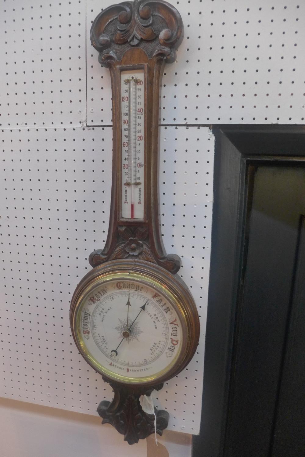 An Early 20th century oak aneroid wheel barometer with thermometer, H.84cm