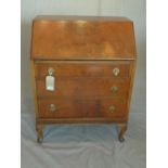 An early 20th century walnut bureau, with drop flap above three drawers, raised on cabriole legs