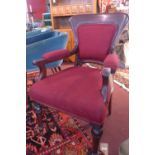 An early 20th century mahogany armchair with red and black upholstery, on turned legs