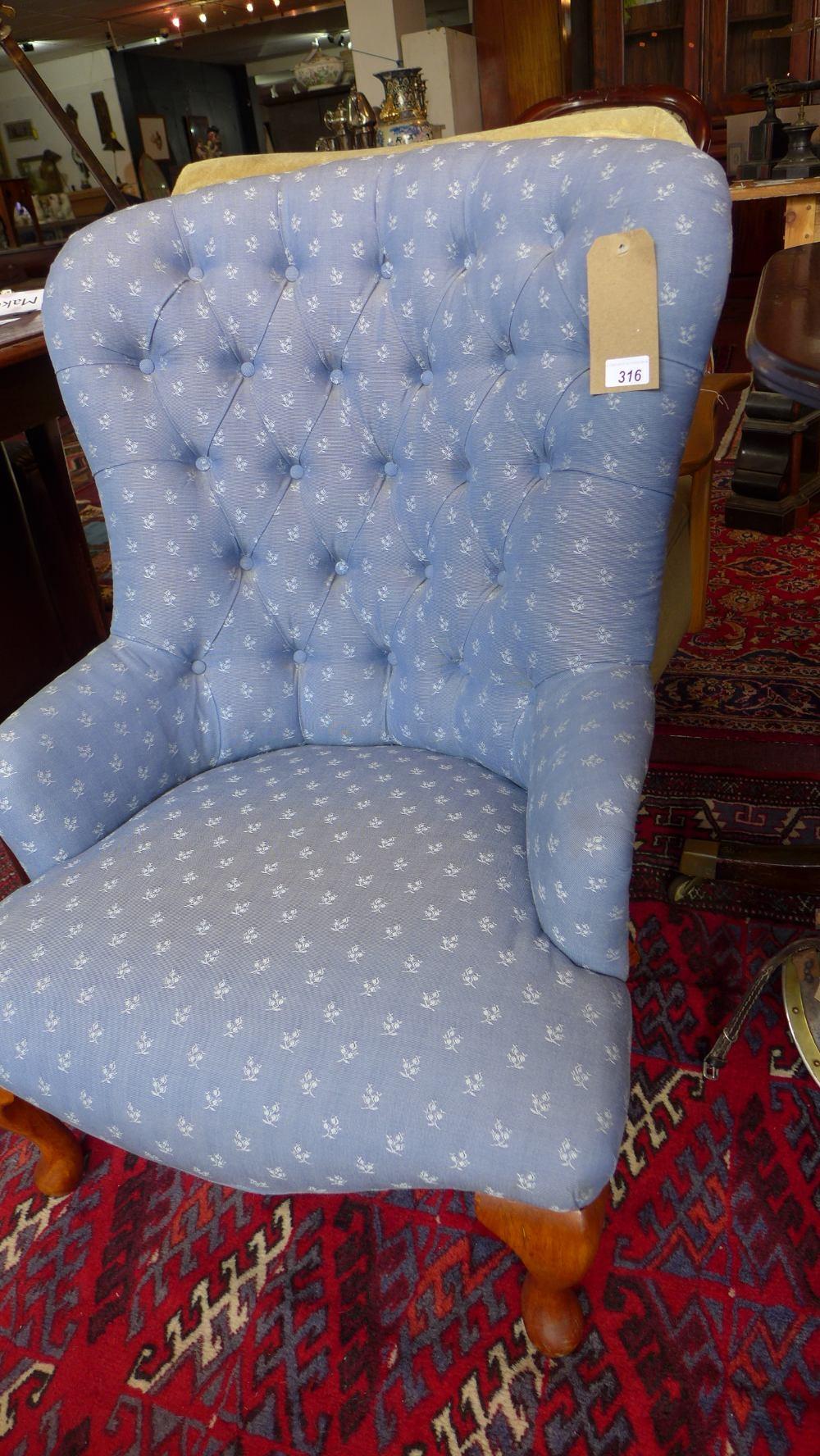 A Victorian style spoon back armchair, with blue floral button back upholstery, raised on cabriole