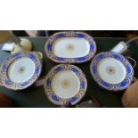A set of four porcelain plates and one serving dish, decorated with gilt ferns to centre within gilt