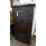 A 17th century oak hall cupboard, with carved lozenge panel door having cast iron hinges, raised