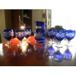 A set of six cobalt blue crystal glasses, decorated with geometric design, together with matching