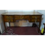 A mid 20th century ladies mahogany bow breakfront writing table, leather skiver, five drawers, two