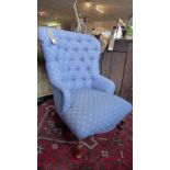 A Victorian style spoon back armchair, with blue floral button back upholstery, raised on turned