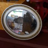 An early 20th century cream and gilt painted oval mirror, with bevelled plate, 79 x 66cm, not convex