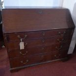 A George III mahogany bureau, with drop flap enclosing fully fitted interior, above four