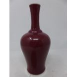 An early 19th century Chinese monochrome ox blood porcelain vase, with narrow neck and elegant body,