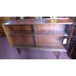 A mid 20th century Danish rosewood bookcase with two glass sliding doors raised on tapered legs, H.