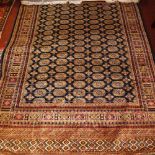 A Bokhara style carpet, with elephant pad motifs on a blue ground, contained by geometric border,