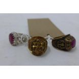 A brass and garnet graduation ring, together with a gilt metal ring inset with two rubies and anchor