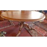 A Victorian mahogany oval loo table, with baluster support, raised on three carved scroll legs and