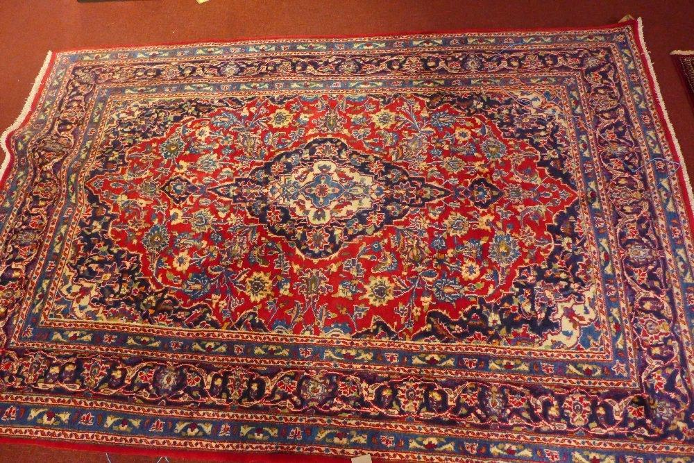 A North East Persian Meshad carpet, central medallion with repeating spandrels on a rouge field