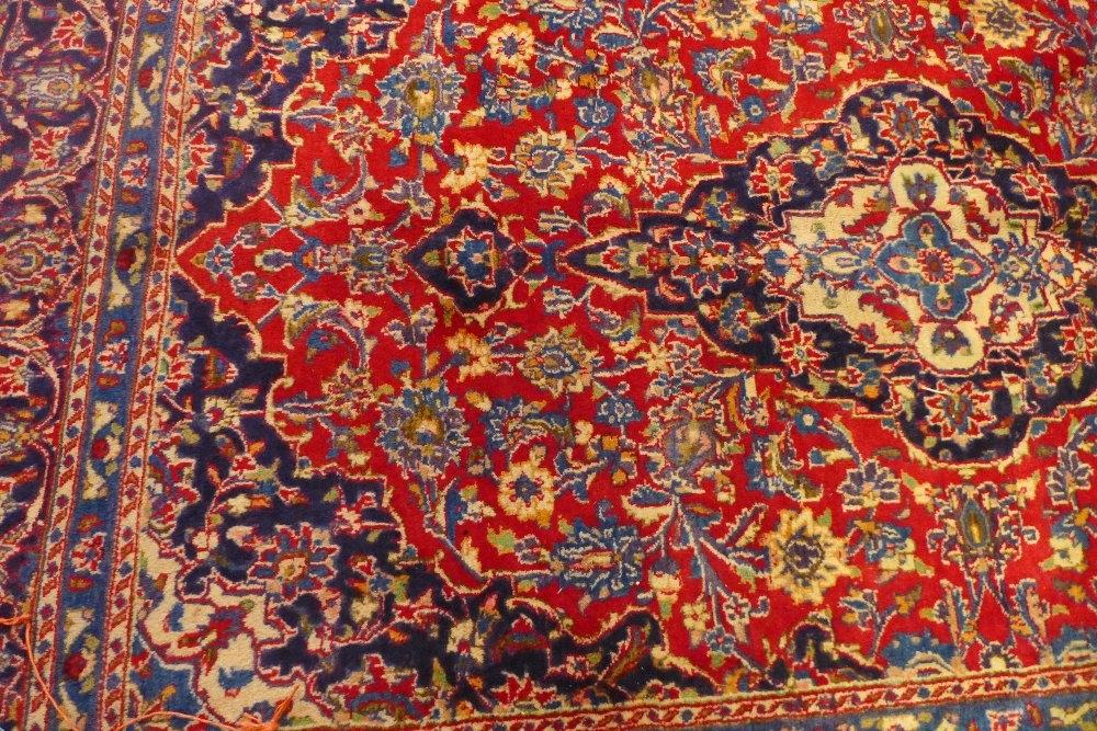 A North East Persian Meshad carpet, central medallion with repeating spandrels on a rouge field - Image 2 of 2