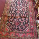 A Persian rug, with medallions on a brown ground, contained by floral borders on a red ground, 180 x