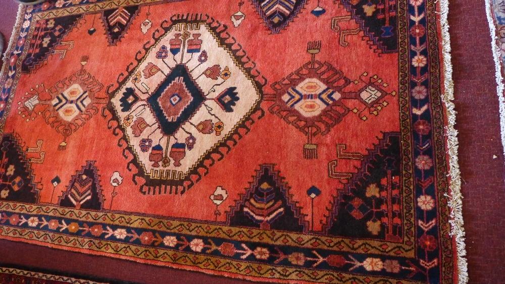 A North West Persian Tafresh rug, central diamond medallion on a rouge field within stylised